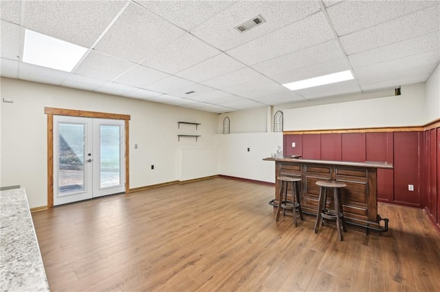 kitchen featuring visible vents, a drop ceiling, french doors, and wood finished floors