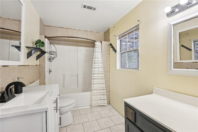 bathroom with visible vents, toilet, shower / tub combo with curtain, tile patterned floors, and vanity