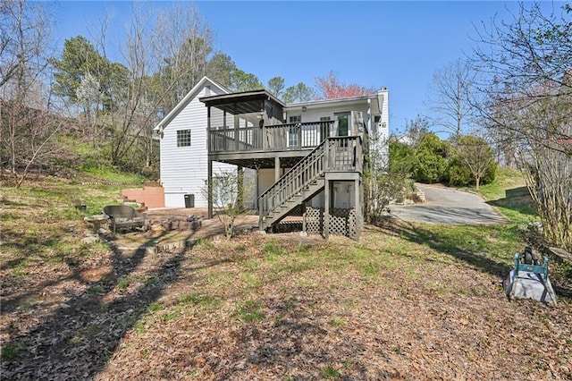 rear view of house with stairway, a deck, and a chimney