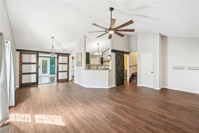 unfurnished living room with baseboards, high vaulted ceiling, stairs, dark wood-type flooring, and ceiling fan with notable chandelier