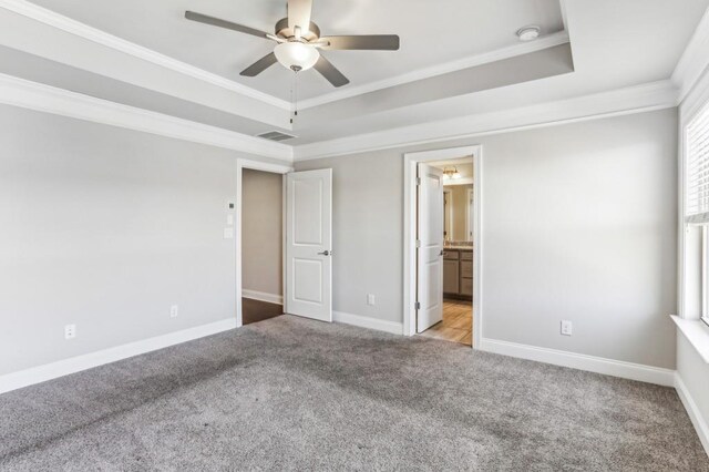 carpeted spare room with a raised ceiling