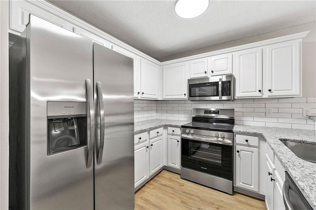 89 Prospect Path, Hiram, GA 30141 - kitchen featuring appliances with stainless steel finishes, white cabinets, light stone counters, and backsplash