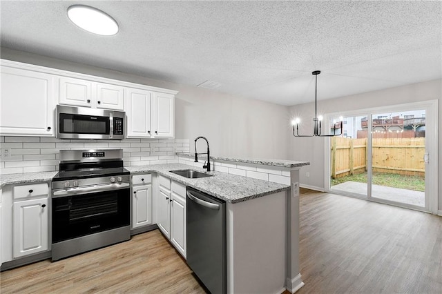 89 Prospect Path, Hiram, GA 30141 - kitchen with appliances with stainless steel finishes, a sink, a peninsula, backsplash, and light wood-style flooring