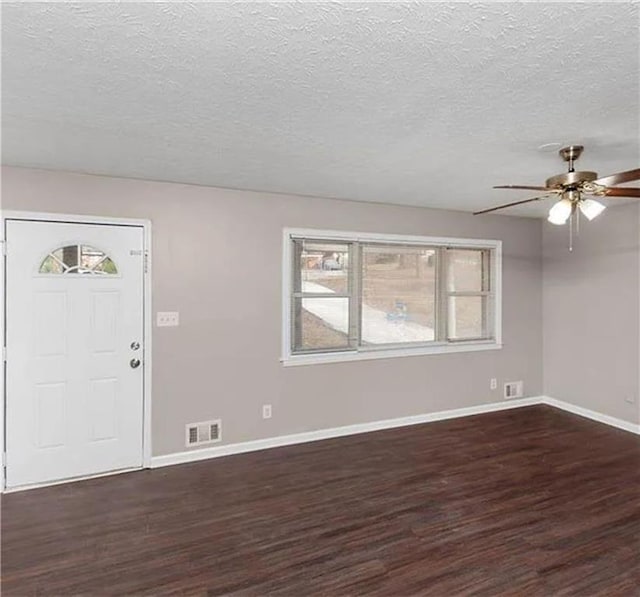 foyer with ceiling fan, dark wood-type flooring, a textured ceiling, and a healthy amount of sunlight