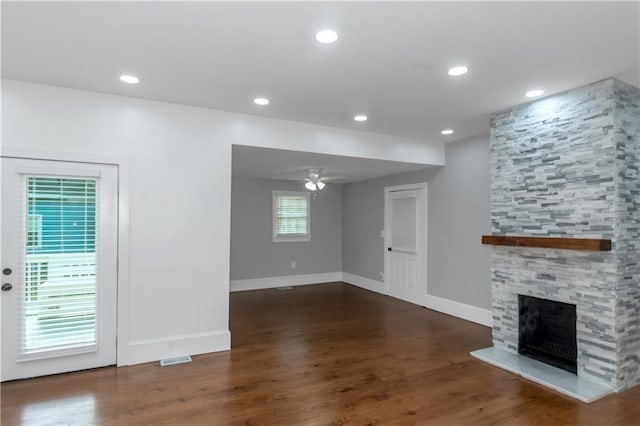 unfurnished living room featuring recessed lighting, ceiling fan, a stone fireplace, and wood finished floors