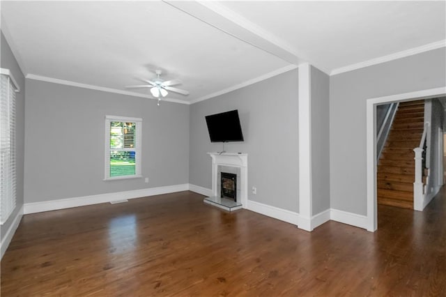 unfurnished living room featuring a fireplace with raised hearth, crown molding, baseboards, and wood finished floors