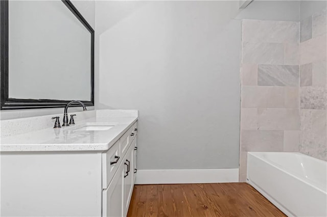 bathroom with baseboards, wood finished floors, and vanity