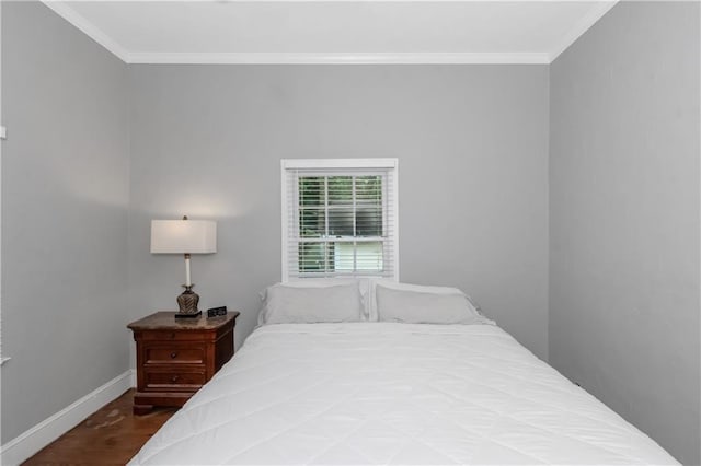 bedroom with baseboards, wood finished floors, and crown molding