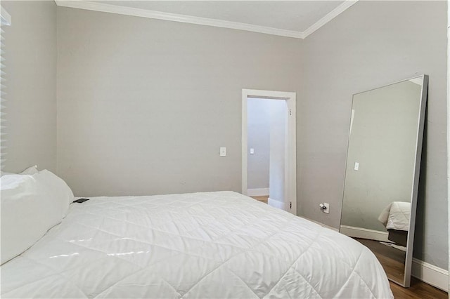 bedroom with ornamental molding, wood finished floors, and baseboards