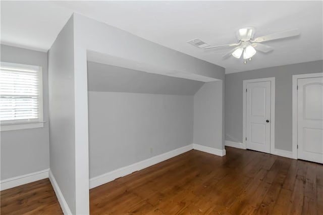 additional living space with lofted ceiling, wood finished floors, visible vents, and baseboards