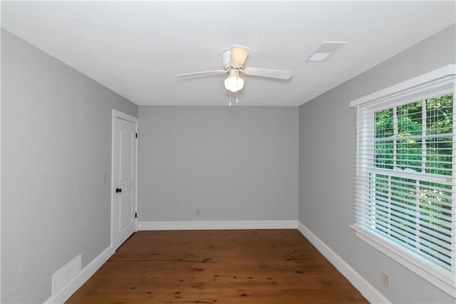 unfurnished room featuring ceiling fan, wood finished floors, visible vents, and baseboards