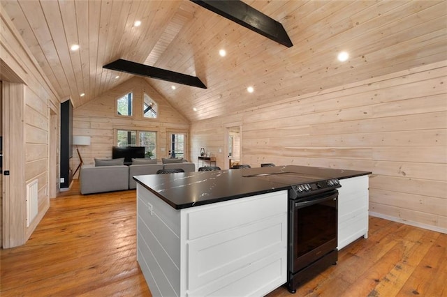 kitchen with dark countertops, black range with electric cooktop, wood walls, wood ceiling, and white cabinetry