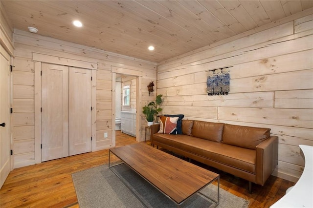 living area featuring recessed lighting, light wood-style flooring, wood ceiling, and wood walls