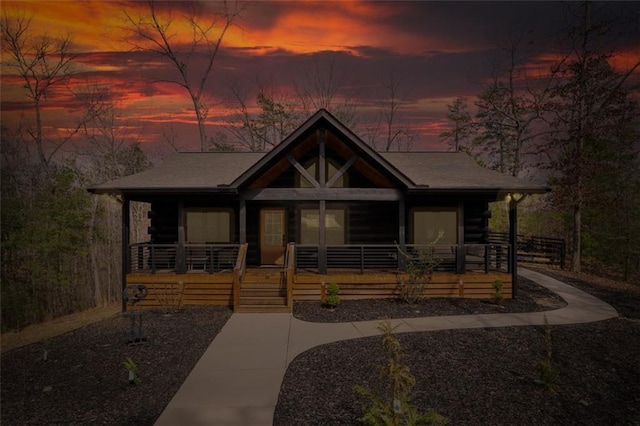 view of front of home featuring log exterior and covered porch