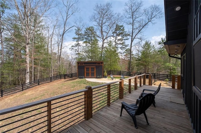 wooden terrace with an outbuilding, a storage unit, and a fenced backyard