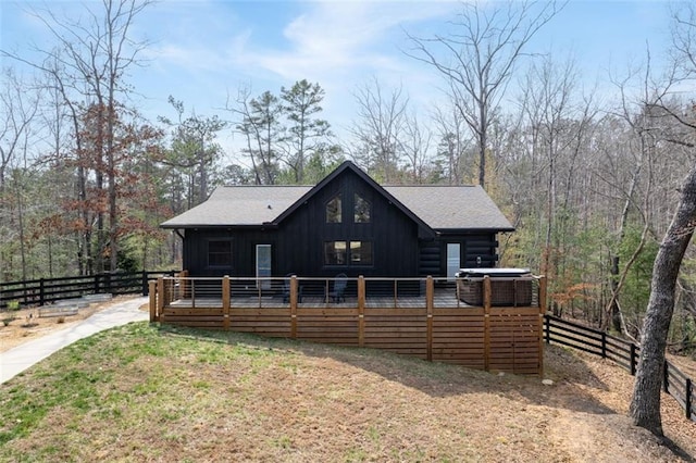 back of house with fence, board and batten siding, and a wooden deck