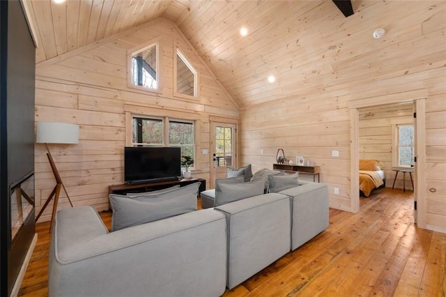 living area featuring hardwood / wood-style floors, plenty of natural light, wood ceiling, and high vaulted ceiling