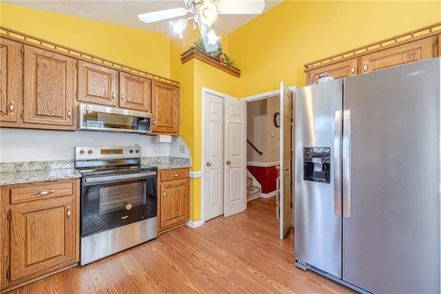 45 Somerset Ct, Covington, GA 30016 - kitchen featuring appliances with stainless steel finishes, brown cabinetry, light wood finished floors, and ceiling fan