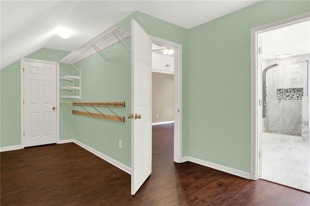 hallway featuring dark hardwood / wood-style flooring and vaulted ceiling