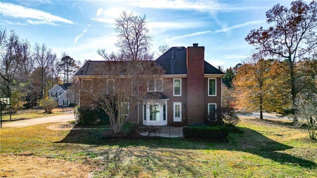 rear view of property featuring a yard and a patio