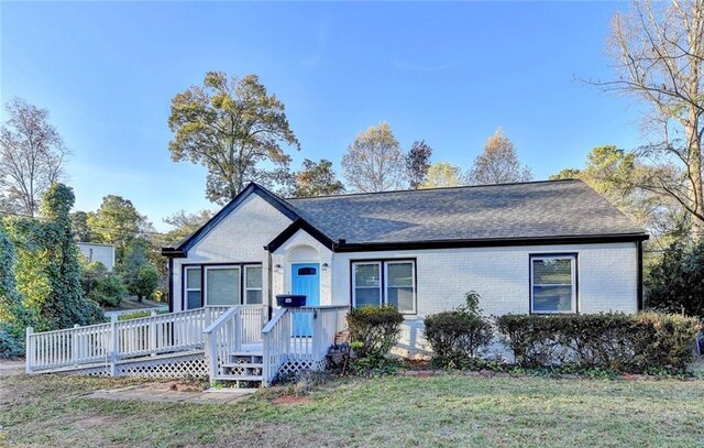 single story home featuring a deck and a front yard