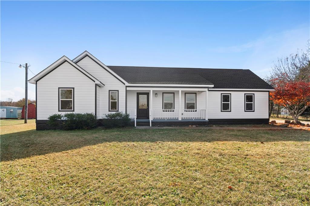 ranch-style house featuring a porch and a front yard