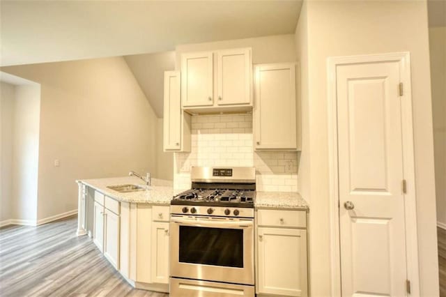 960 Park Place St, Social Circle, GA 30025 - kitchen with gas range, a sink, baseboards, tasteful backsplash, and light wood-style floors