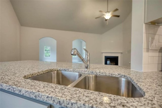 960 Park Place St, Social Circle, GA 30025 - kitchen view of a sink, a ceiling fan, light stone countertops, and a fireplace