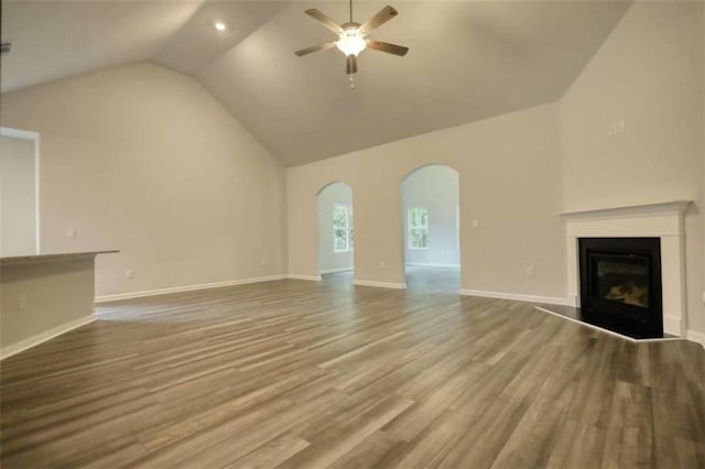 960 Park Place St, Social Circle, GA 30025 - unfurnished living room with arched walkways, ceiling fan, wood finished floors, a glass covered fireplace, and baseboards