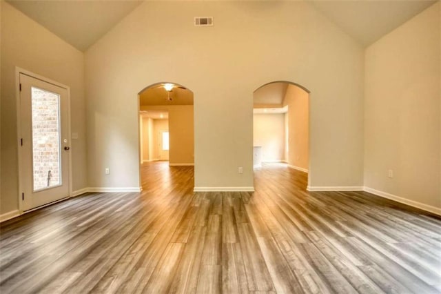 960 Park Place St, Social Circle, GA 30025 - unfurnished room with arched walkways, wood finished floors, high vaulted ceiling, plenty of natural light, and baseboards