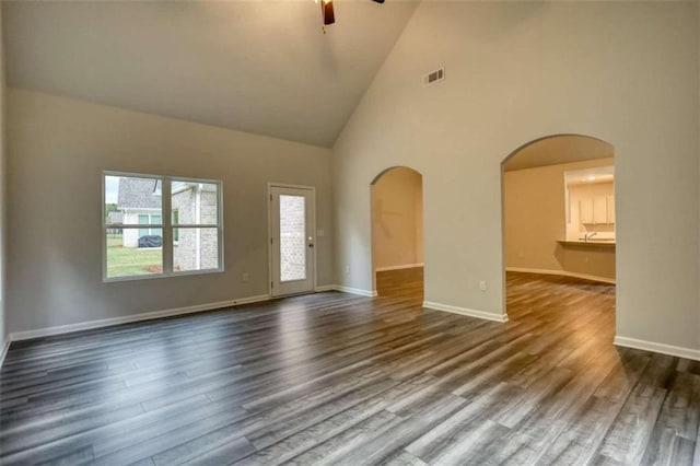 960 Park Place St, Social Circle, GA 30025 - unfurnished living room with arched walkways, a ceiling fan, high vaulted ceiling, dark wood finished floors, and baseboards