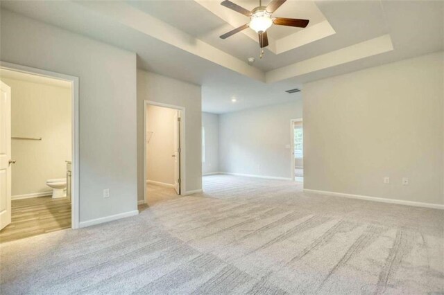 960 Park Place St, Social Circle, GA 30025 - spare room featuring a tray ceiling, ceiling fan, light carpet, and baseboards