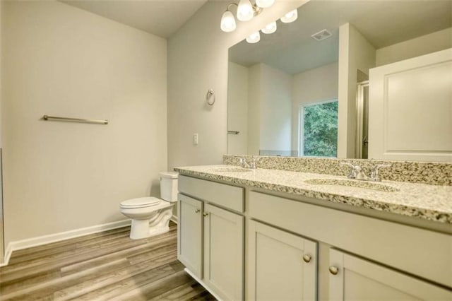 960 Park Place St, Social Circle, GA 30025 - bathroom featuring double vanity, toilet, baseboards, wood finished floors, and a shower with door