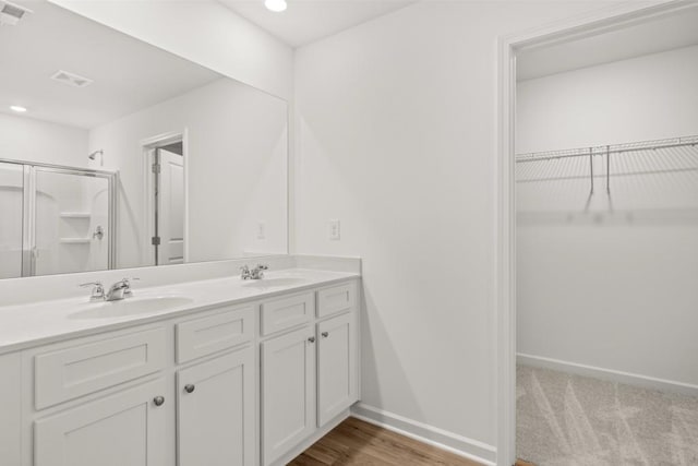 bathroom with vanity, an enclosed shower, and wood-type flooring