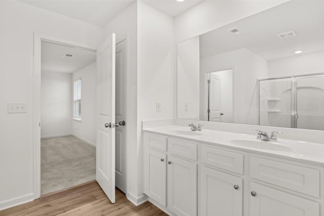 bathroom featuring hardwood / wood-style flooring, vanity, and walk in shower