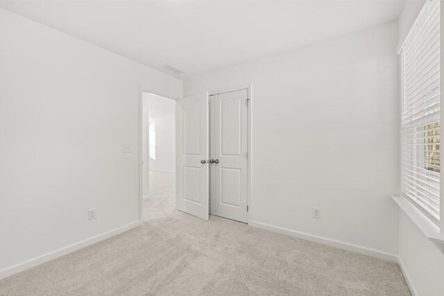 spare room featuring light colored carpet