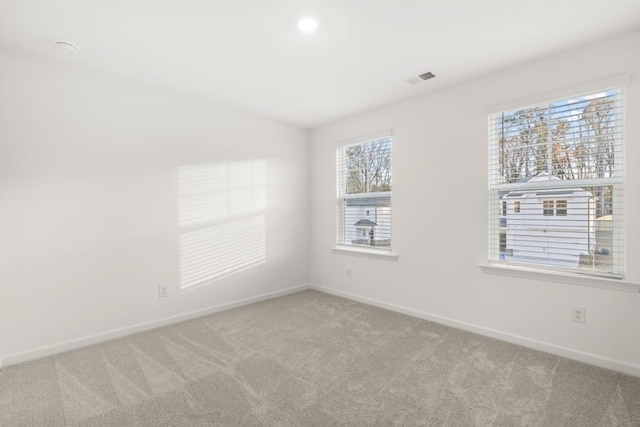 carpeted spare room featuring a healthy amount of sunlight