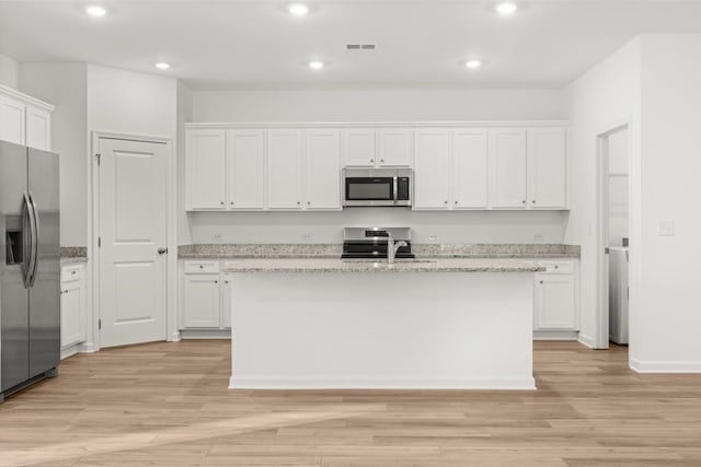 kitchen featuring white cabinets, an island with sink, and stainless steel appliances