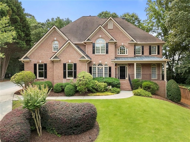 10135 High Falls Pointe Pointe, Johns Creek, GA 30022 - colonial-style house featuring brick siding, a front yard, and covered porch