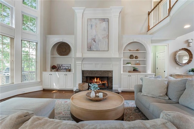 10135 High Falls Pointe Pointe, Johns Creek, GA 30022 - living area with a towering ceiling, a high end fireplace, dark wood finished floors, and built in features