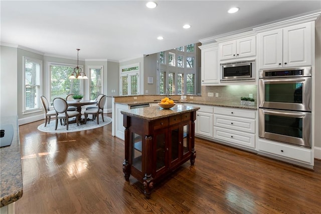 10135 High Falls Pointe Pointe, Johns Creek, GA 30022 - kitchen with appliances with stainless steel finishes, ornamental molding, dark wood finished floors, a chandelier, and white cabinetry