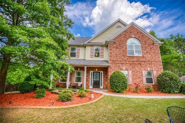 craftsman-style home with brick siding and a front yard