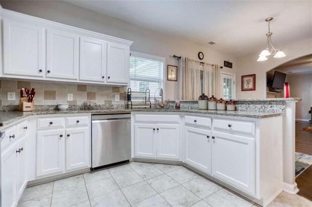 kitchen featuring stainless steel dishwasher, a peninsula, white cabinets, a sink, and light stone countertops