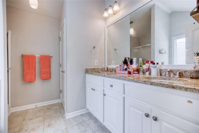 full bath with a stall shower, double vanity, baseboards, and tile patterned flooring