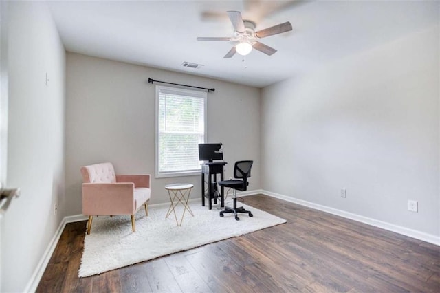 living area featuring wood finished floors, ceiling fan, baseboards, and a desk