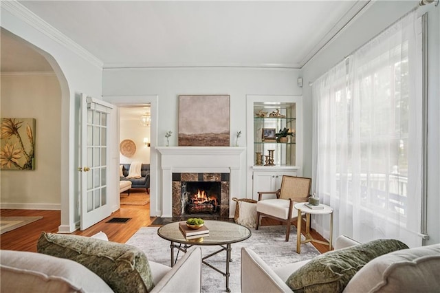 615 Sycamore Dr, Decatur, GA 30030 - living area featuring ornamental molding, arched walkways, a fireplace, wood finished floors, and baseboards