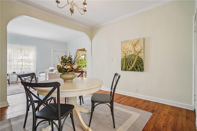 615 Sycamore Dr, Decatur, GA 30030 - dining room with arched walkways, wood finished floors, a chandelier, crown molding, and baseboards