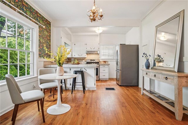 615 Sycamore Dr, Decatur, GA 30030 - kitchen with appliances with stainless steel finishes, extractor fan, white cabinetry, a peninsula, and light wood-type flooring