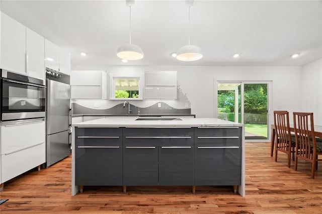 1492 Sagewood Cir, Stone Mountain, GA 30083 - kitchen featuring stainless steel appliances, white cabinetry, modern cabinets, light wood finished floors, and recessed lighting