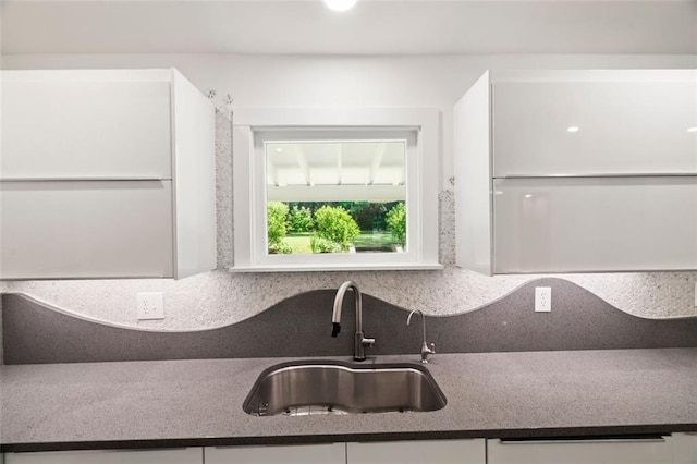 1492 Sagewood Cir, Stone Mountain, GA 30083 - kitchen with a sink, dark countertops, white cabinets, and tasteful backsplash